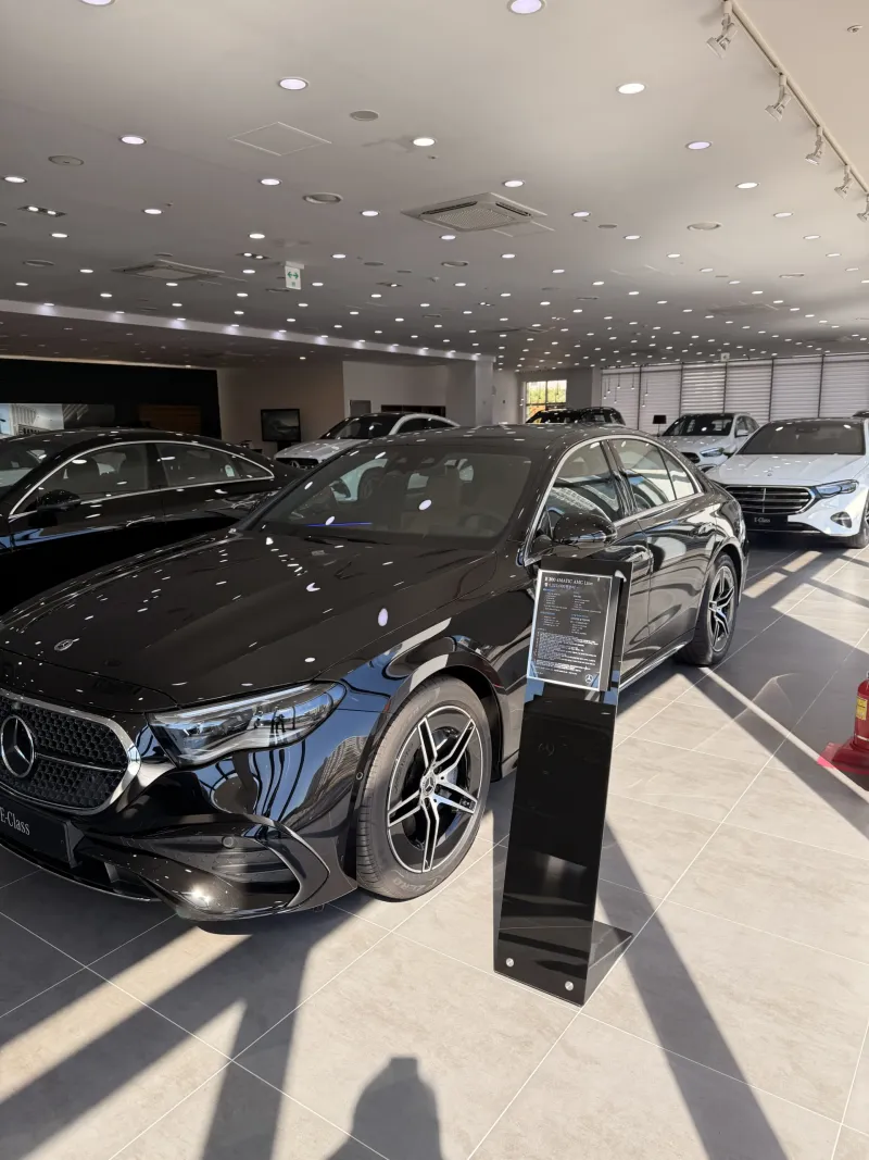 의정부 쇼룸 전시 블랙 벤츠 E 300 4MATIC AMG Line 앞 측면과 안내 스탠드