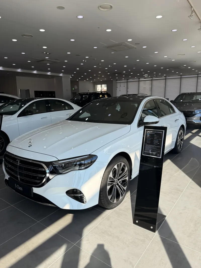의정부 쇼룸 전시 화이트 벤츠 E 350 e 4M EX 앞 측면과 안내 스탠드